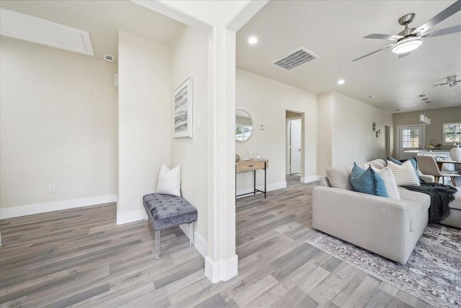 Living room with ceiling fan and light wood-type flooring