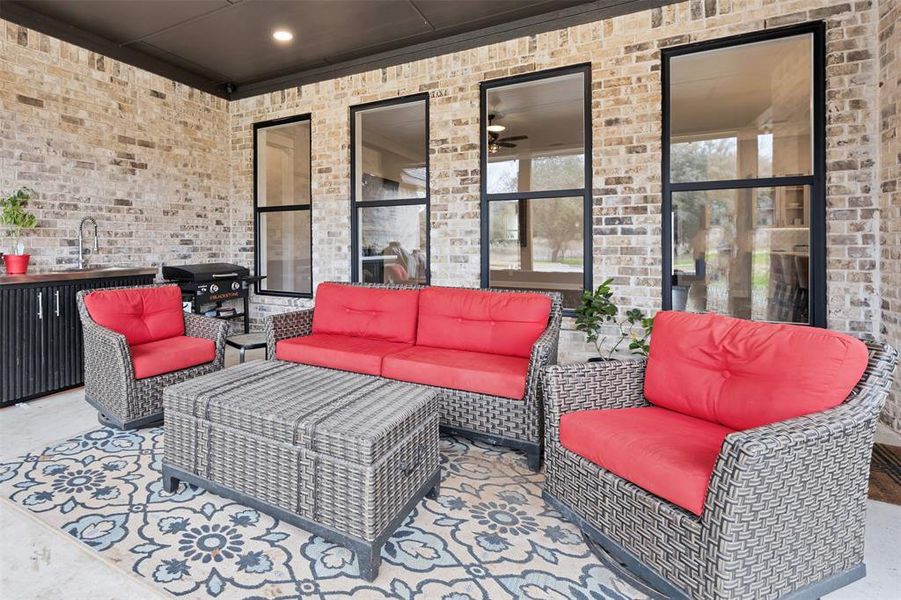 View of patio with outdoor lounge area, a grill, and sink