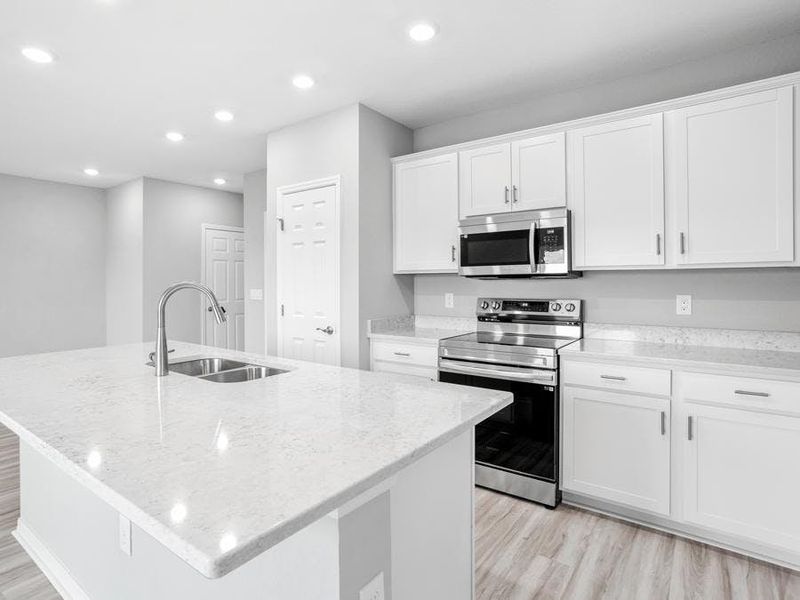 Your bright, open kitchen is centered around an island, and includes a convenient pantry - Blakely by Highland Homes Your bright, open kitchen is centered around an island, and includes a convenient pantry - Blakely by Highland Homes