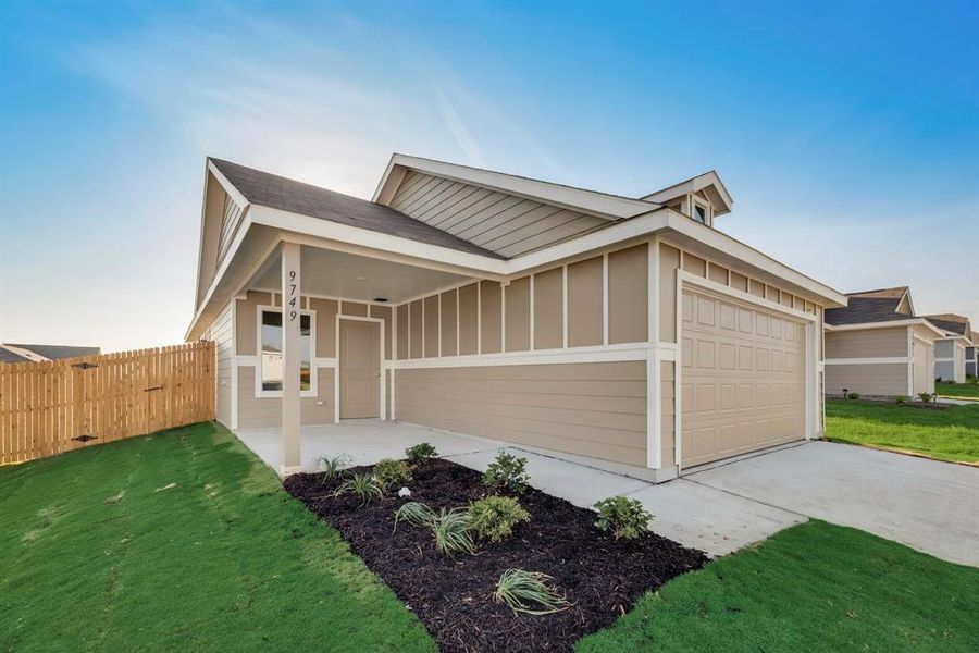 View of front of home with a garage and a front lawn