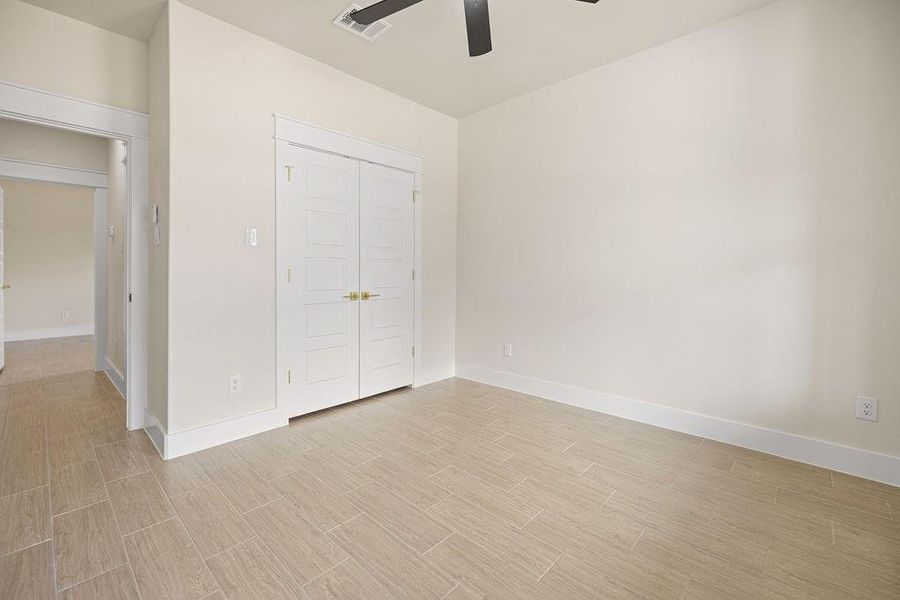 Unfurnished bedroom featuring baseboards, visible vents, a ceiling fan, wood finish floors, and a closet