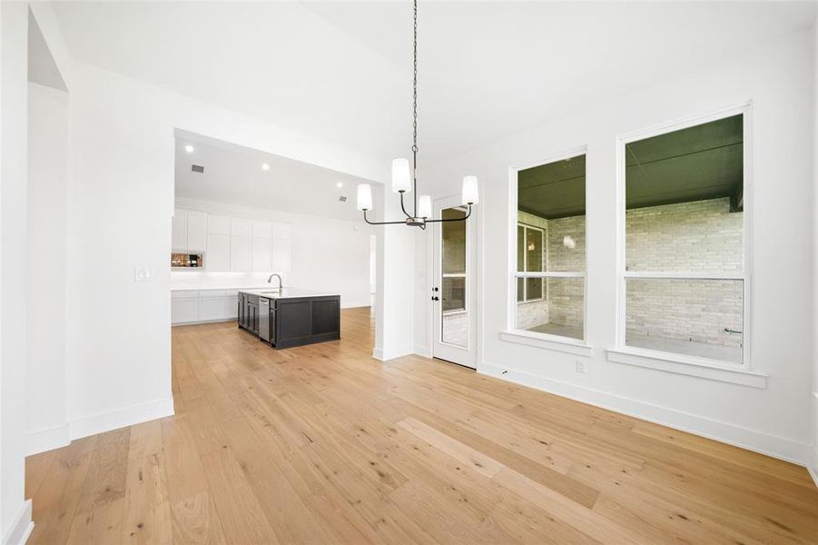 Unfurnished dining area featuring light wood-style flooring, a chandelier, and recessed lighting