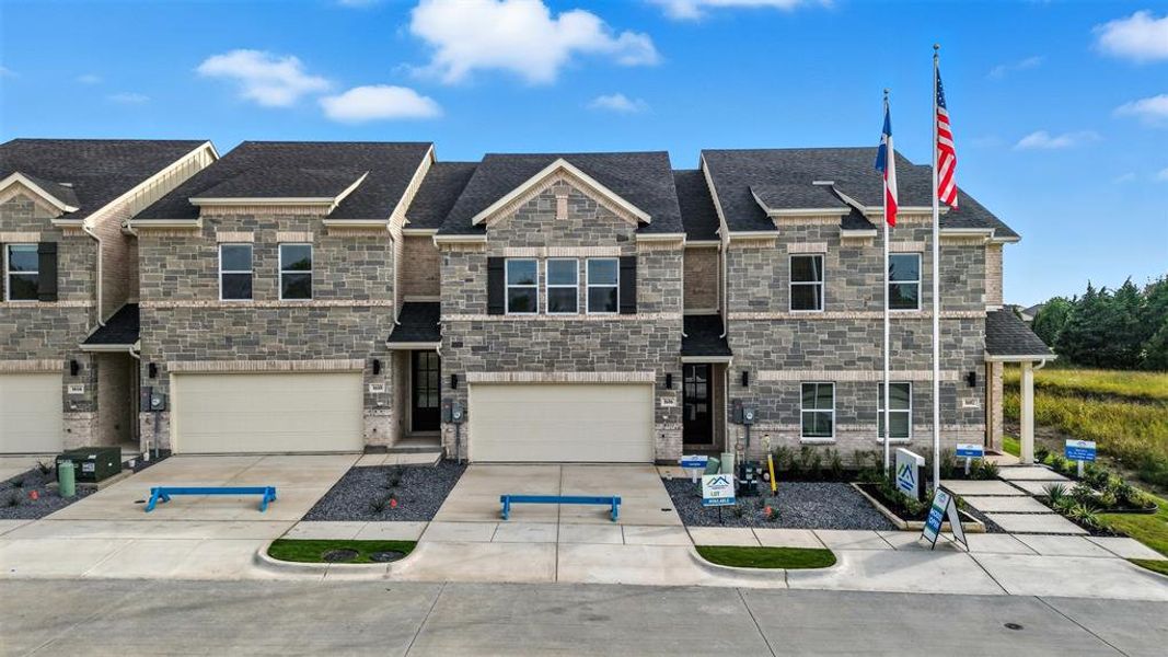 View of front facade with concrete driveway, stone siding, and a garage View of front facade with concrete driveway, stone siding, and a garage