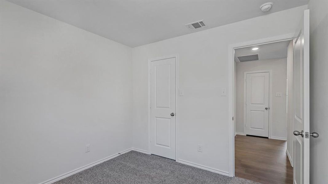 Unfurnished bedroom with baseboards and dark colored carpet Unfurnished bedroom with baseboards and dark colored carpet