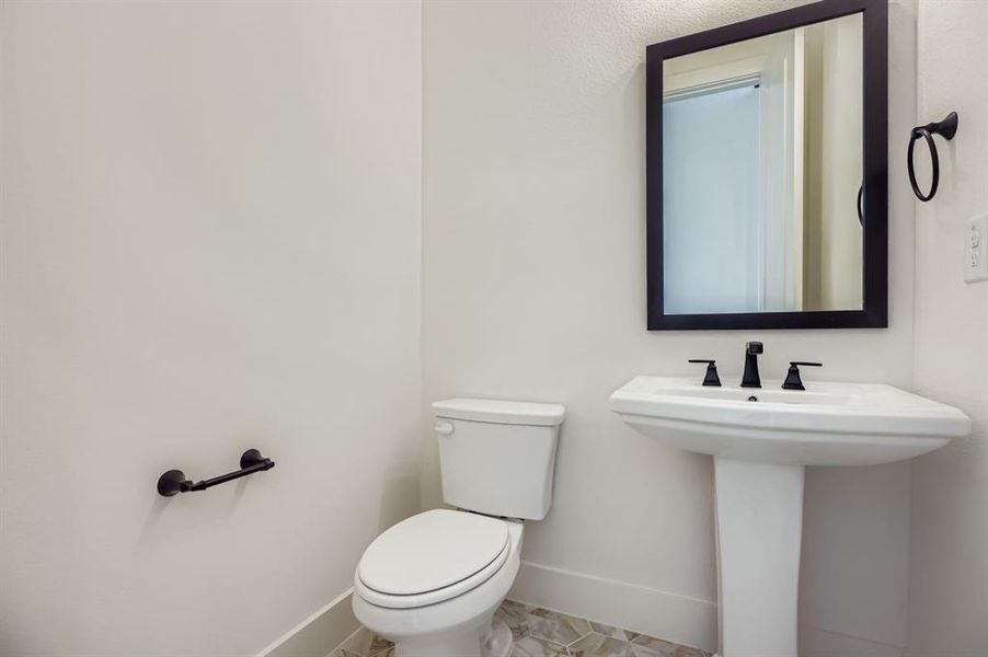 Half bath featuring baseboards and toilet Half bath featuring baseboards and toilet