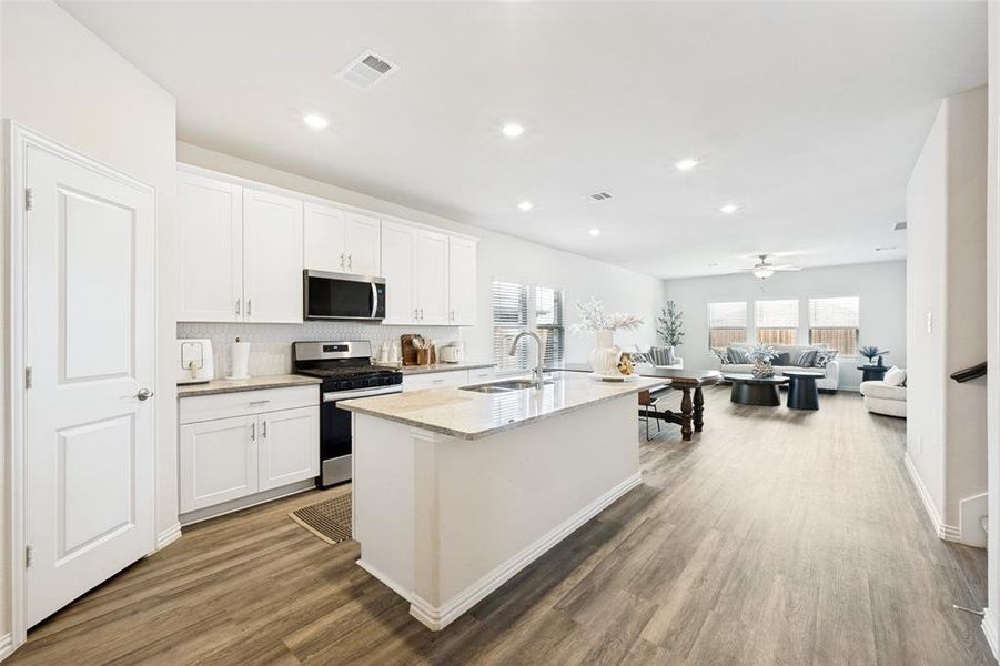 Open-concept living space with wood-finish flooring extending throughout Open-concept living space with wood-finish flooring extending throughout