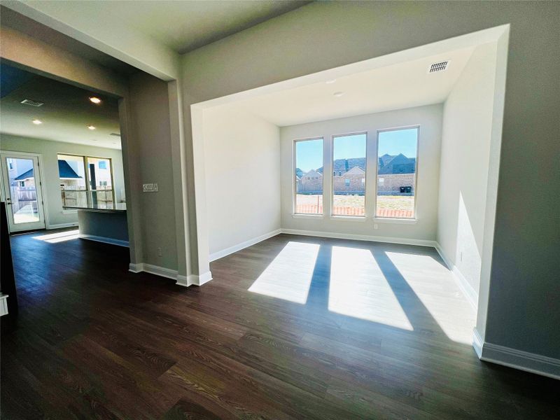 Unfurnished room featuring baseboards and dark wood-style floors