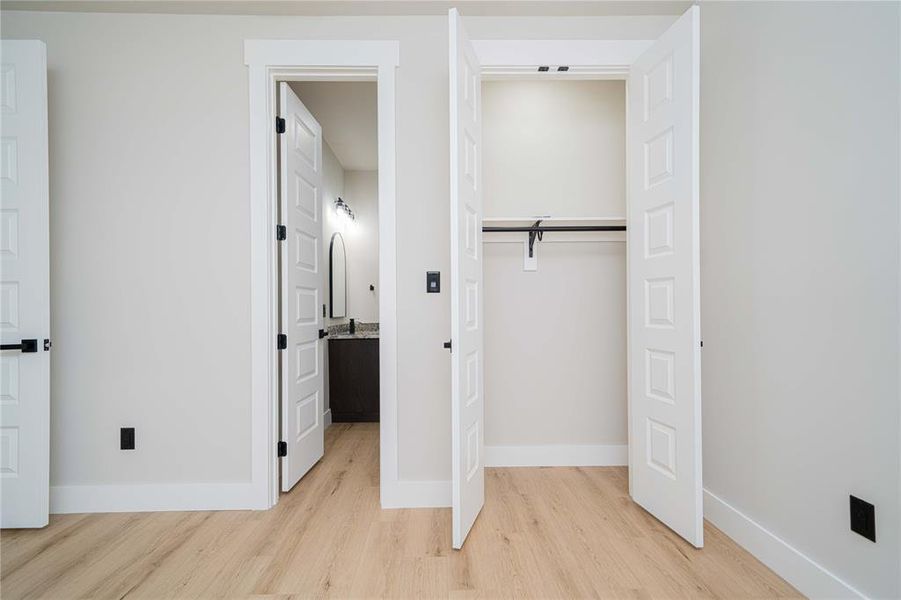 Interior room featuring wood-finish flooring and white baseboards