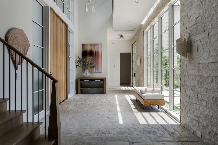 Bright hallway with floor-to-ceiling windows and modern stone accent wall.*Images depict previously completed homes by Roberson Building Group and are intended solely to showcase builder quality and craftsmanship.