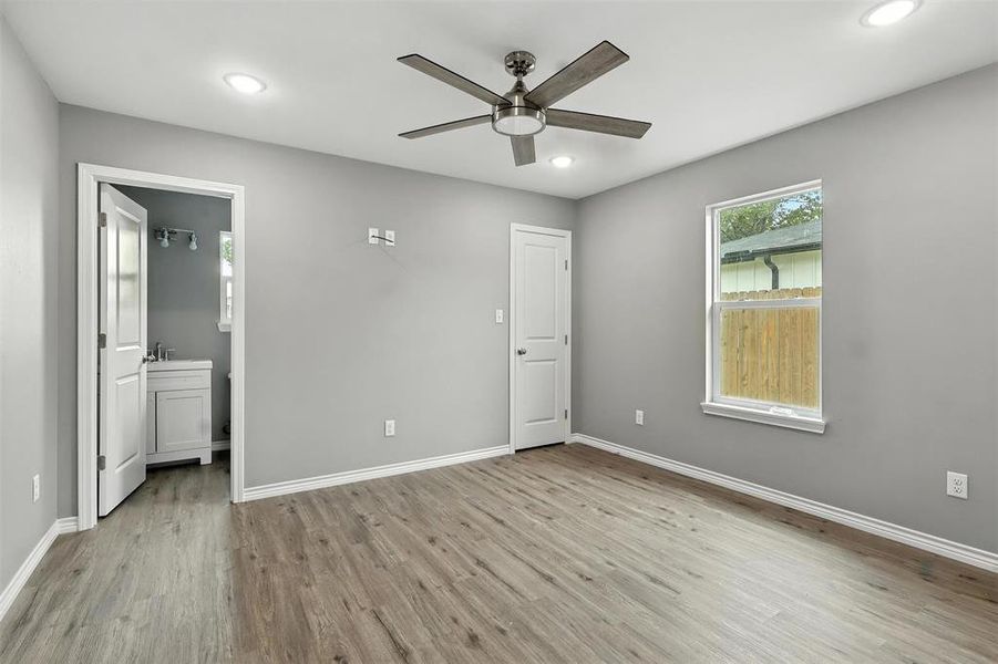Unfurnished bedroom featuring wood finished floors, recessed lighting, ensuite bathroom, and ceiling fan Unfurnished bedroom featuring wood finished floors, recessed lighting, ensuite bathroom, and ceiling fan