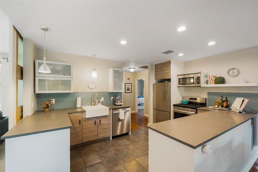 A contemporary kitchen showcasing stainless steel appliances, sleek countertops, and mosaic tile backsplash. A contemporary kitchen showcasing stainless steel appliances, sleek countertops, and mosaic tile backsplash.