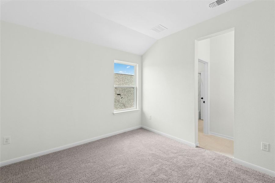 Unfurnished room featuring light carpet and lofted ceiling Unfurnished room featuring light carpet and lofted ceiling