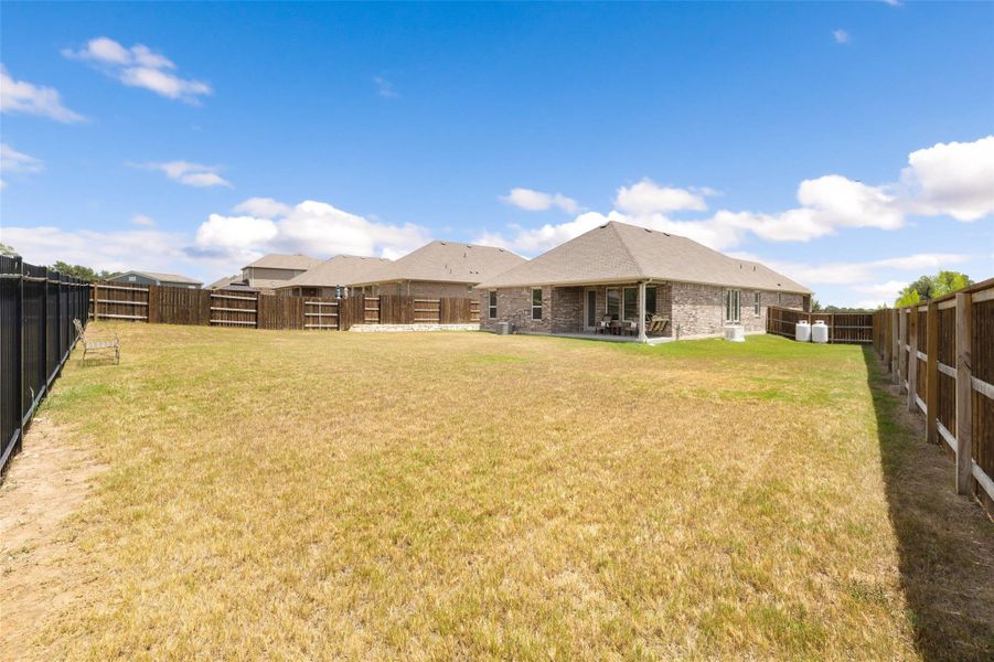 Rear view of property featuring a fenced backyard, a patio area, and brick siding Rear view of property featuring a fenced backyard, a patio area, and brick siding