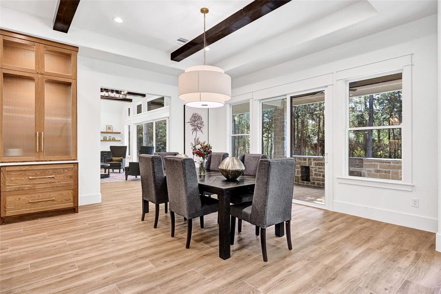 Breakfast nook featuring custom lighting and sliding doors that lead to an outdoor kitchen.