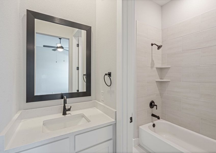 The Jack-and-Jill bathroom has a tiled shower-tub combo and toilet that joins two of the secondary bedrooms.
