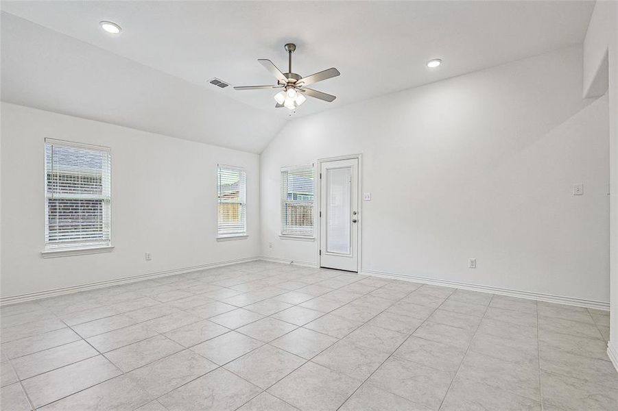 Tiled empty room featuring lofted ceiling and ceiling fan