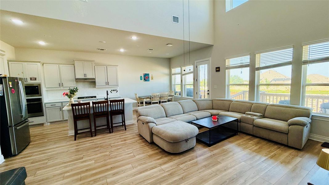 A spacious, open-concept interior unites a well-appointed kitchen, dining area, and inviting living room, all illuminated by generous natural light.