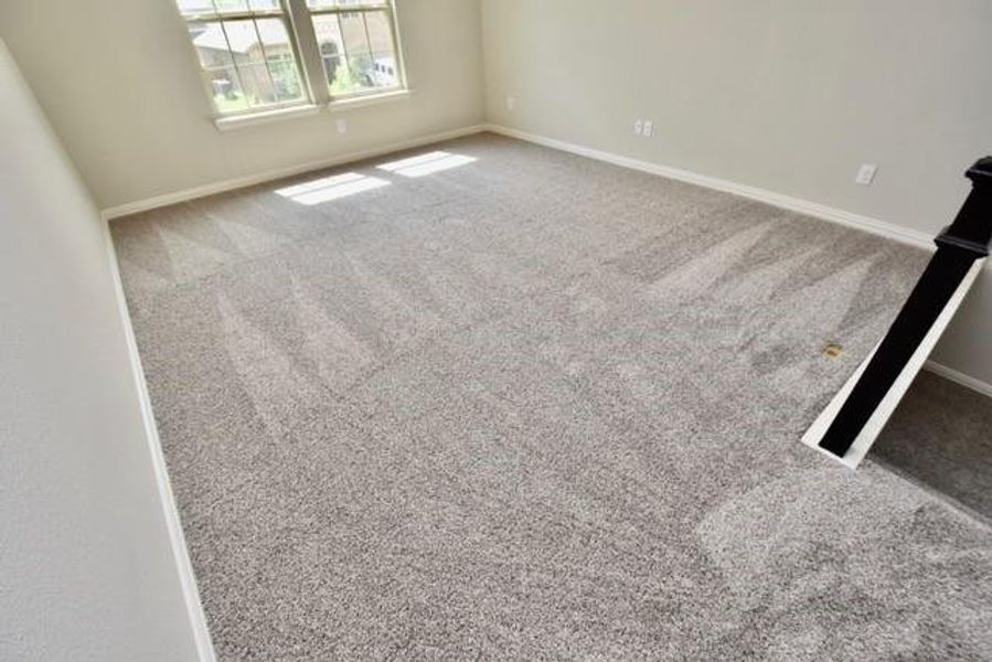 Carpeted spare room featuring baseboards Carpeted spare room featuring baseboards
