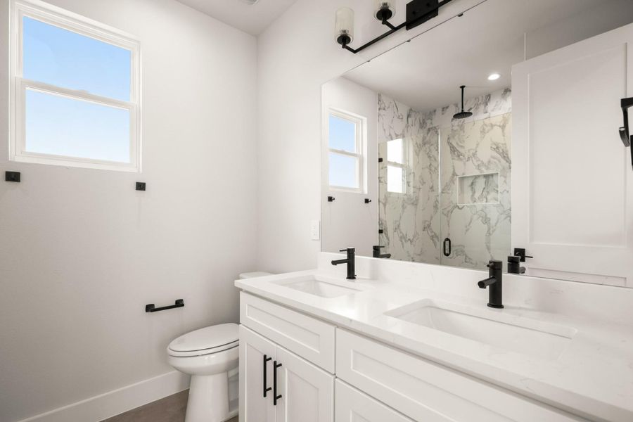 Bathroom with a marble finish shower and double vanity Bathroom with a marble finish shower and double vanity