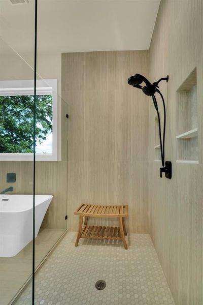 Bathroom with tile patterned floors and tiled shower