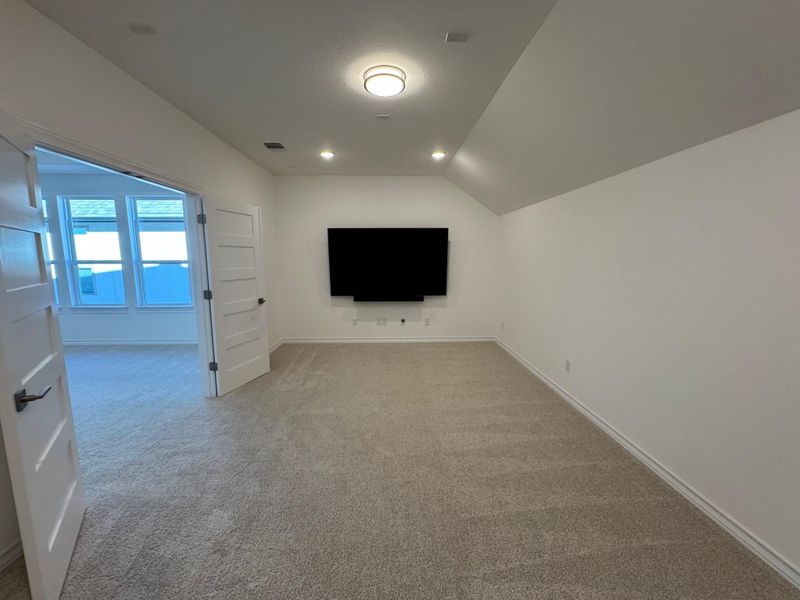 Additional living space with lofted ceiling, light colored carpet, and recessed lighting