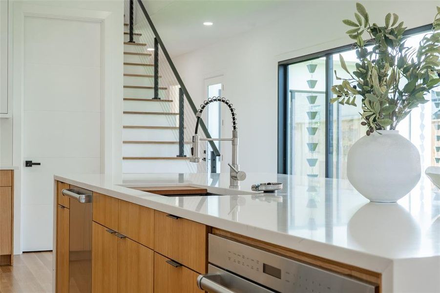 Bar featuring light hardwood / wood-style floors, sink, and stainless steel dishwasher