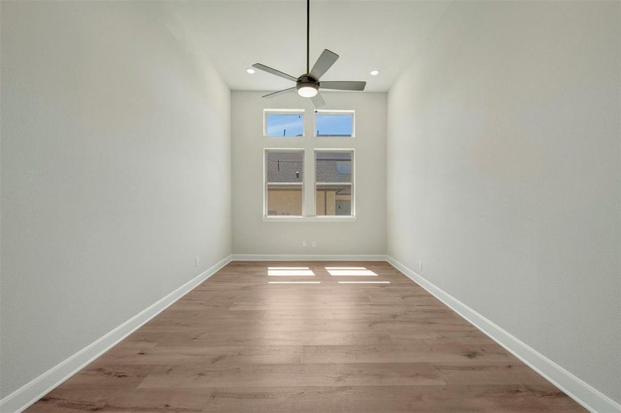 Spare room featuring wood finished floors, ceiling fan, and recessed lighting