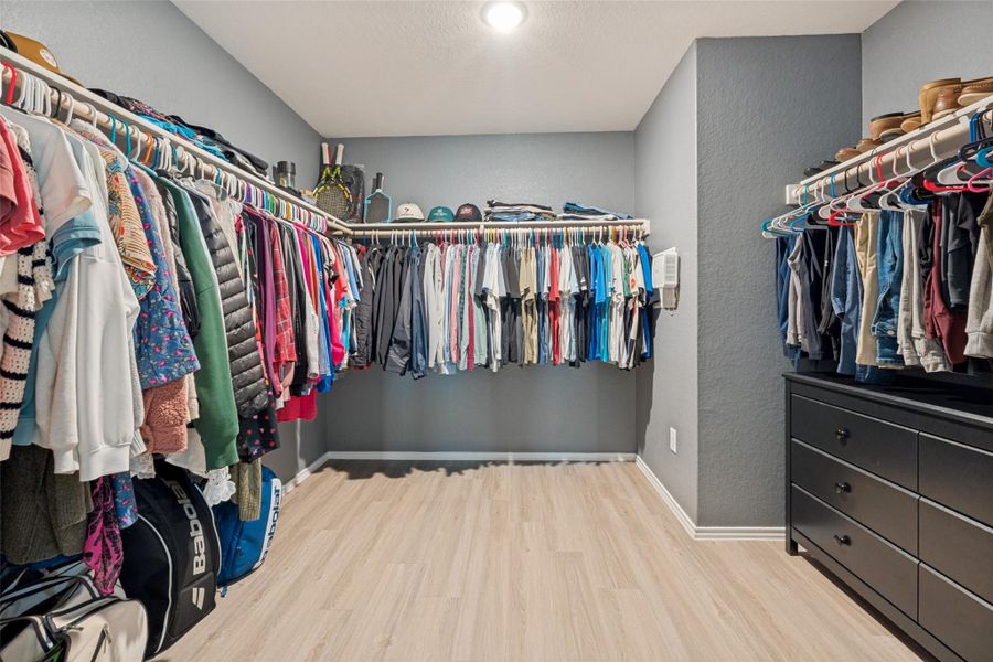 Ample hanging space and shelving create a well-organized closet system.