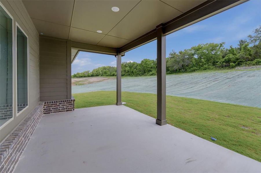 Covered outdoor patio featuring a concrete floor, recessed lighting, and support columns