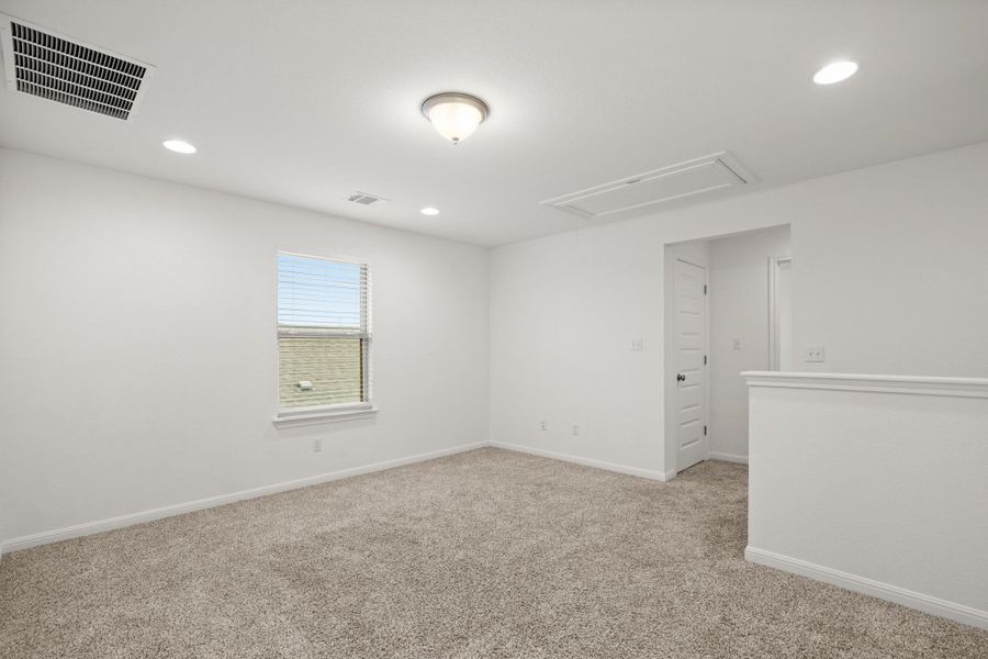 Carpeted empty room featuring attic access and recessed lighting
