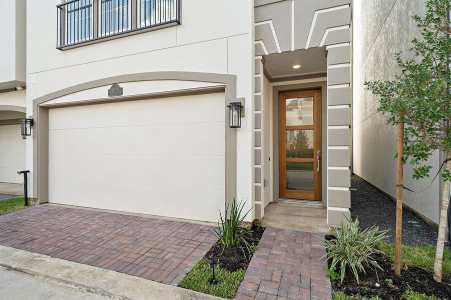 A beautiful entrance to your new home with pavers and a stunning glass front door.