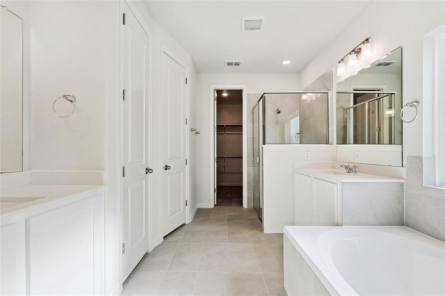 Bathroom with shower with separate bathtub, tile patterned floors, and vanity