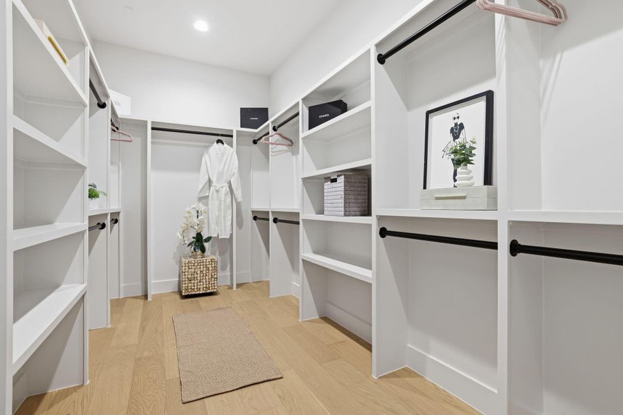 Walk in closet with light wood-type flooring