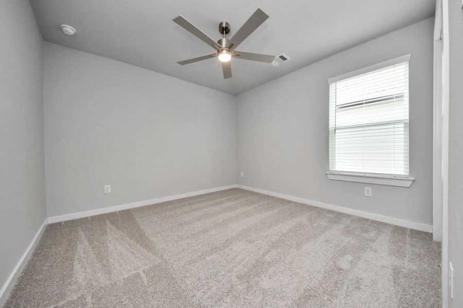Secondary bedroom features plush carpeting, large windows that let in plenty of natural light, bright paint, and spacious closets.