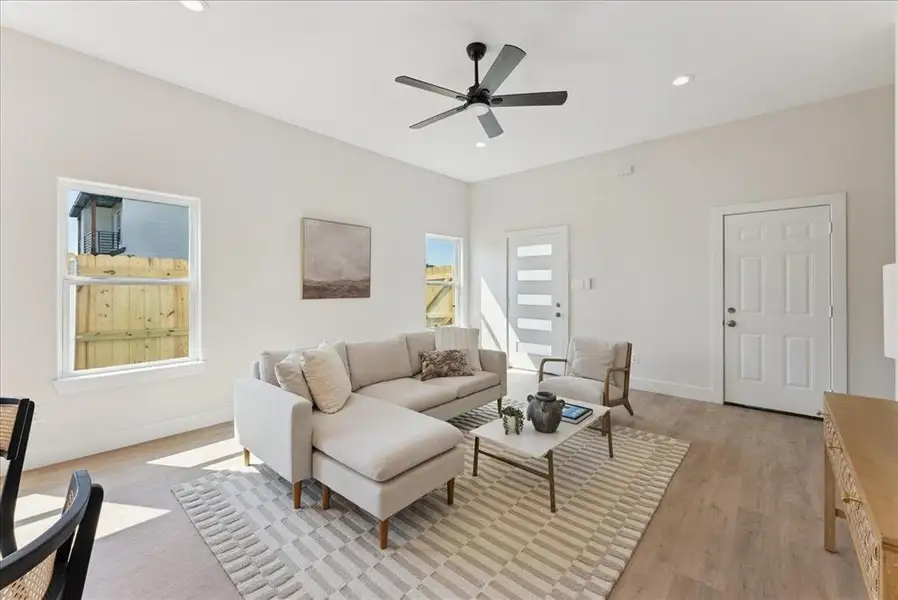 Living room featuring light wood-type flooring, recessed lighting, and a ceiling fan