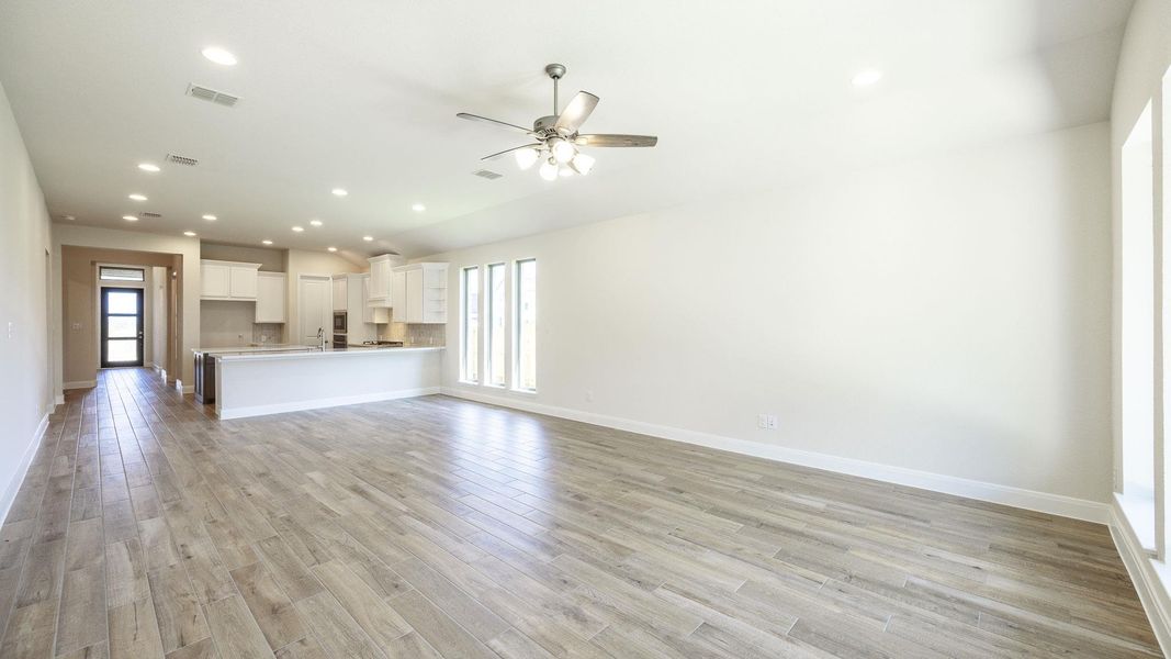 Unfurnished living room with recessed lighting, light wood-style flooring, a ceiling fan, and lofted ceiling Unfurnished living room with recessed lighting, light wood-style flooring, a ceiling fan, and lofted ceiling