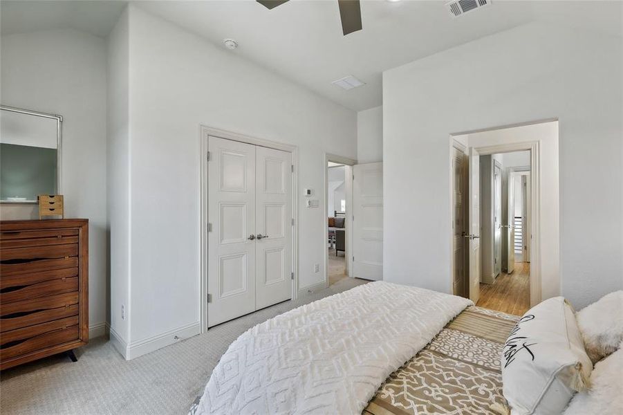 Bedroom featuring vaulted ceilings, light neutral wall paint, and a double-door entryway