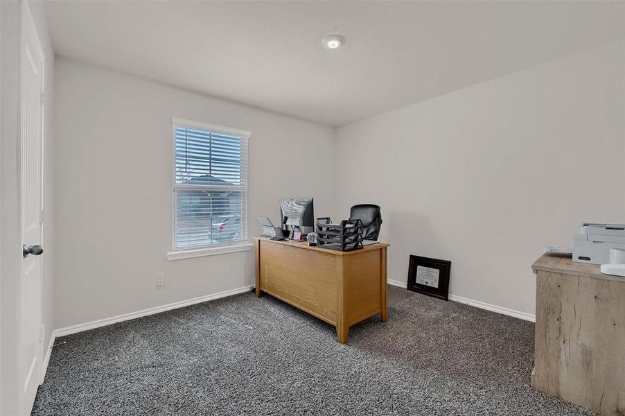 Carpeted office space featuring baseboards