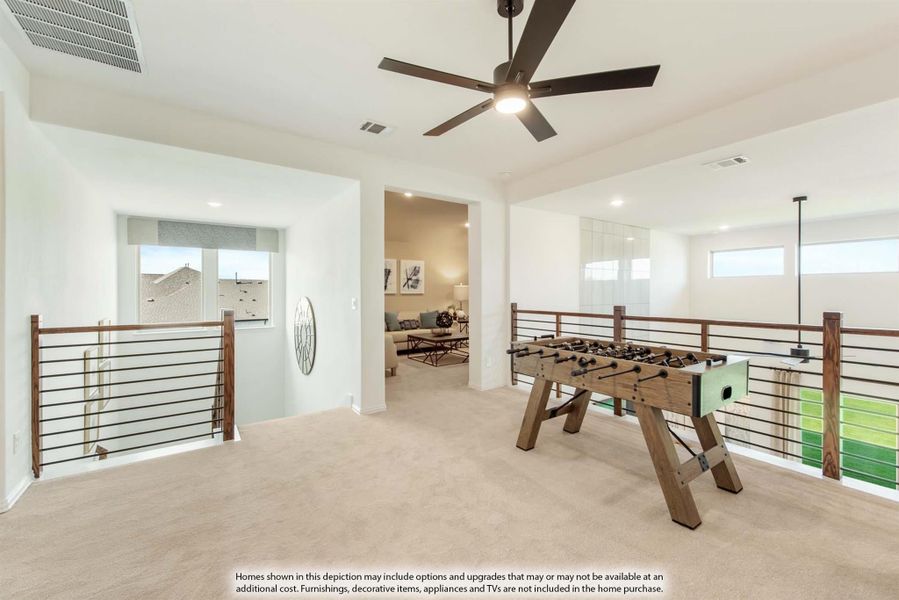 Open loft game room with foosball table, ceiling fan, and wood railing overlooking lower level