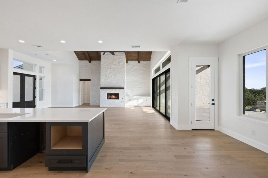 A spacious great room showcases soaring vaulted ceilings with exposed beams and a statement fireplace. A spacious great room showcases soaring vaulted ceilings with exposed beams and a statement fireplace.