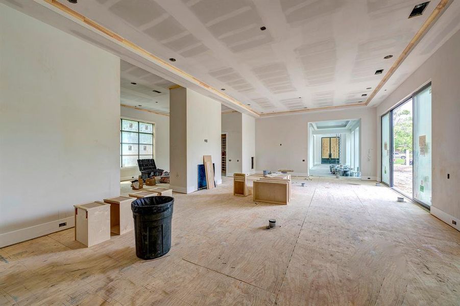 This view shows the large living room with flexible space, wine room, and wet bar on the other side of the two-sided fireplace. Great layout for entertaining! Stage of construction as of April 3, 2025. This view shows the large living room with flexible space, wine room, and wet bar on the other side of the two-sided fireplace. Great layout for entertaining! Stage of construction as of April 3, 2025.