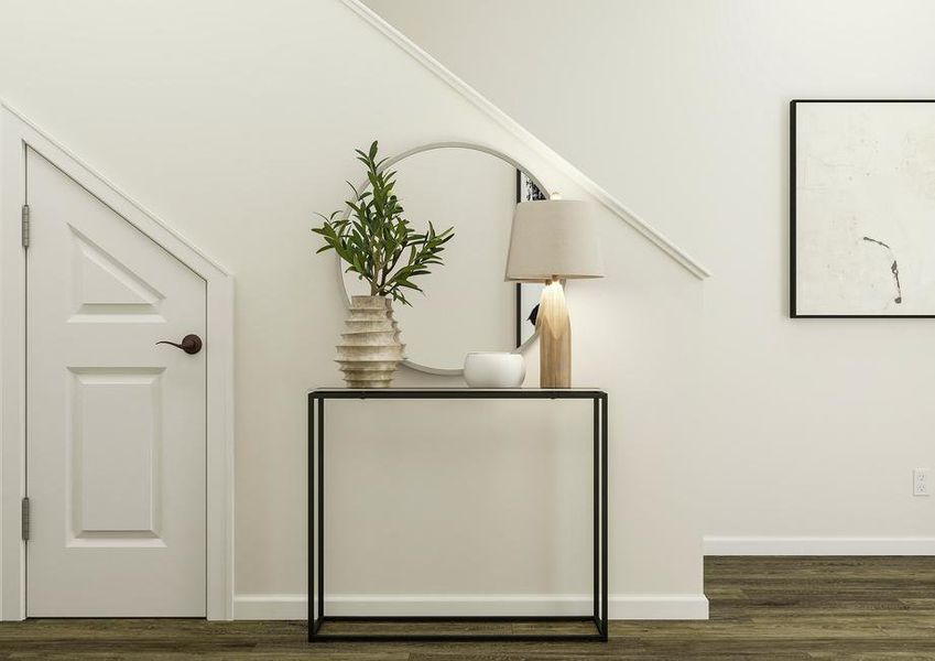 Rendering of the entry of the home
  showing a console table and mirror against the stairs. A door leading to
  storage beneath the stairs is also visible.