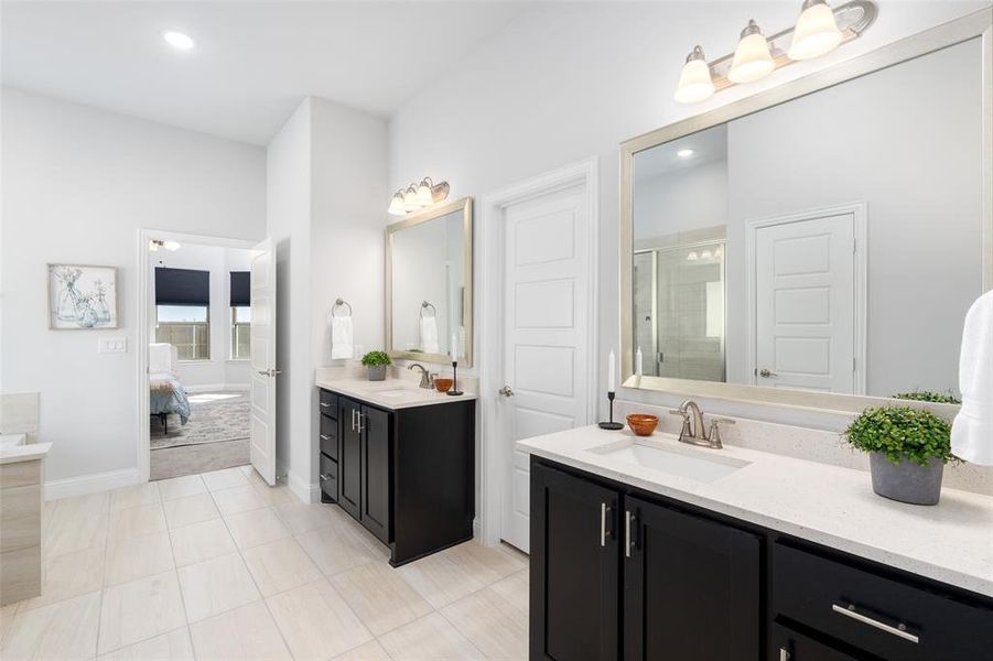 Bathroom with tile patterned flooring, a shower with shower door, and vanity