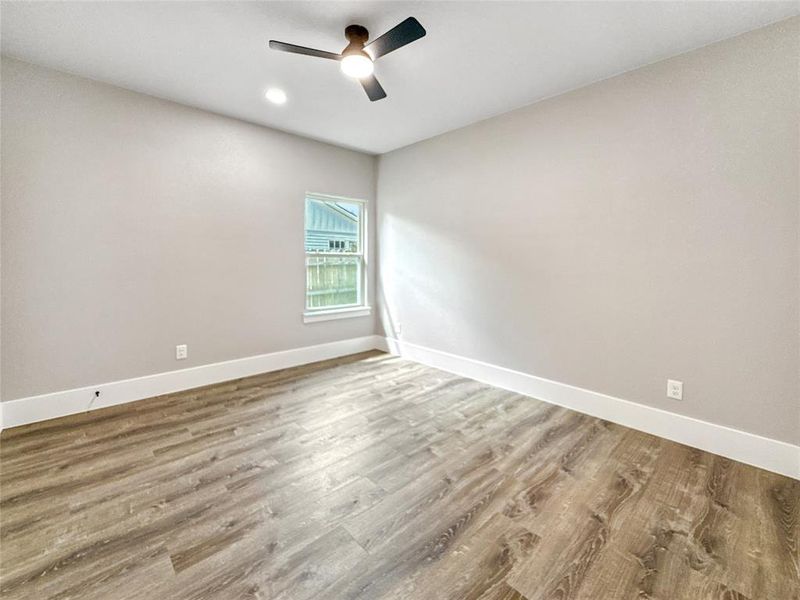 Spare room with light wood-type flooring, a ceiling fan, and recessed lighting