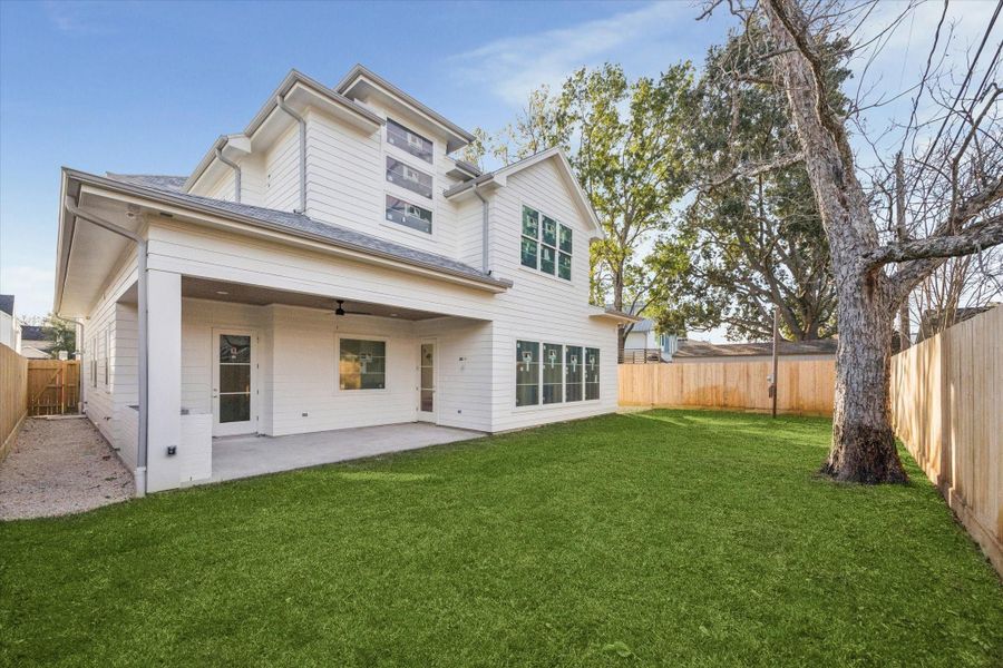 BACKYARD - Generous backyard pairs a wide lawn with a covered patio, creating space for outdoor dining, play, or future enhancements. Privacy fencing and mature trees add a sense of separation while keeping the setting bright and open. -- Construction as of 1/5/26