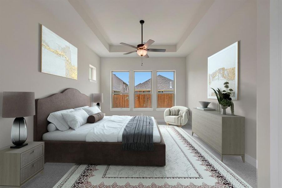 Carpeted bedroom with a ceiling fan and a tray ceiling