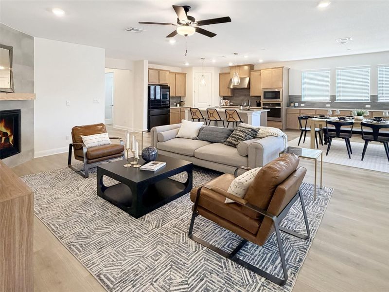 Living room featuring recessed lighting, light wood finished floors, ceiling fan, and a large fireplace