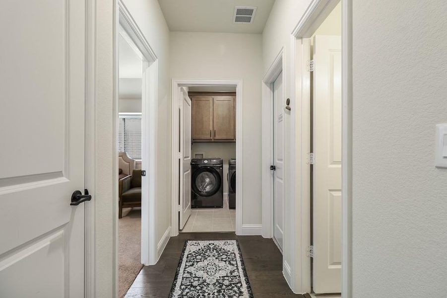 Laundry area with cabinet space, washer and dryer, and dark wood finished floors
