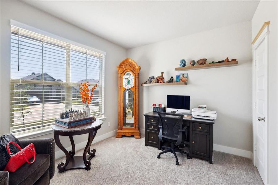 Office space featuring light colored carpet and a healthy amount of sunlight