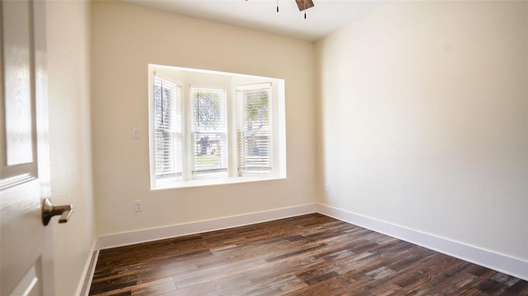 Bedroom with wood-style flooring, bay window with coverings, and ceiling fan Bedroom with wood-style flooring, bay window with coverings, and ceiling fan